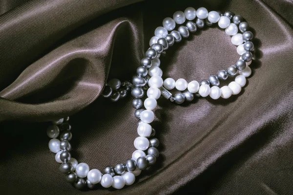 Naszyjniki z pereł naturalnych na tle jedwabiu — Zdjęcie stockowe