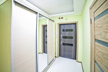 İçi modern, büyük, yeşil tonlarda uzun bir koridor.