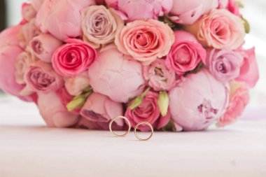 Güzel bir buket şakayık ve yeni evliler için alyanslı diğer pembe çiçekler.