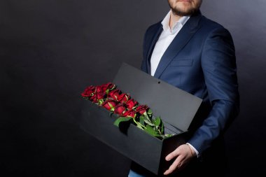 Erkek, sevdiği kadına orijinal bir kutuda kırmızı güller verir.