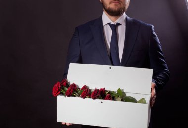 Erkek, sevdiği kadına orijinal bir kutuda kırmızı güller verir.