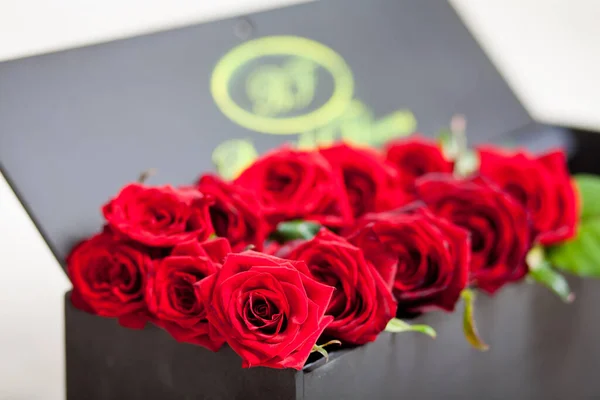 Erkek, sevdiği kadına orijinal bir kutuda kırmızı güller verir.