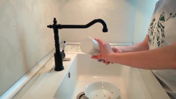 厨房里的女孩把脏兮兮的餐具放在水流下洗 — 图库视频影像