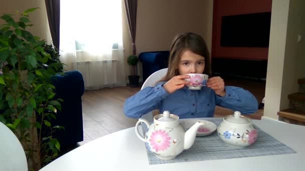 Κορίτσι Κάθεται Στο Τραπέζι Χύνει Και Πίνει Τσάι Από Μια — Αρχείο Βίντεο