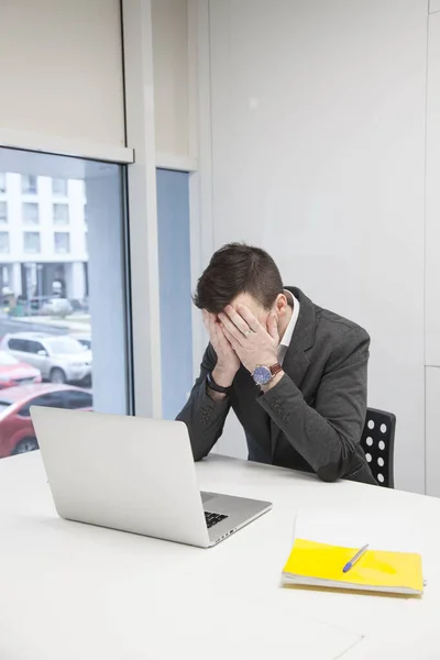 Genç işadamı bilgisayardaki belgelerle çalışıyor.
