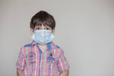 Koronavirüs salgını sırasında maske takan genç bir çocuk.