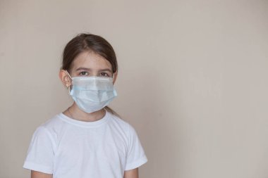 Koronavirüs salgını sırasında maske takan genç bir kız.