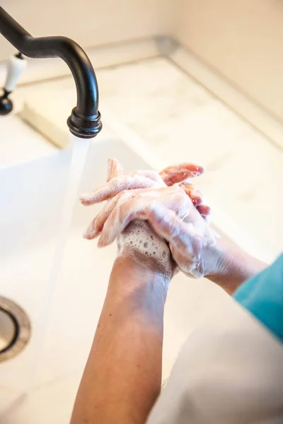 A girl washes her hands with soap to prevent infection with the covid-19 virus