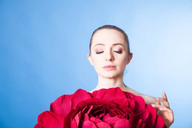 Dövmeleri ve yumuşak cildi olan genç ve güzel bir model. Spa tedavisinden sonra kırmızı bir gül ve kozmetik ürünleri.