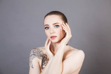 Dövmeleri ve kaplıca ve kozmetik ürünlerinden sonra yumuşak bir cildi olan genç ve güzel bir model.