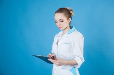 Korunaklı maskeli güzel kadın doktor. Stüdyonun mavi arka planında Coronavirus 'a karşı.