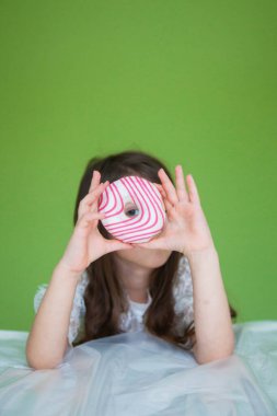 Beyaz elbiseli genç bir kız tatlı bir çörek yiyecek.