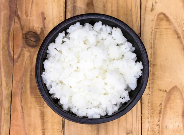 Colocar el arroz en una taza sobre una mesa de madera . —  Fotos de Stock