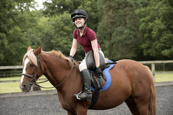 Ponnyryttare åtdragning omkrets banden på en sadel — Stockfoto