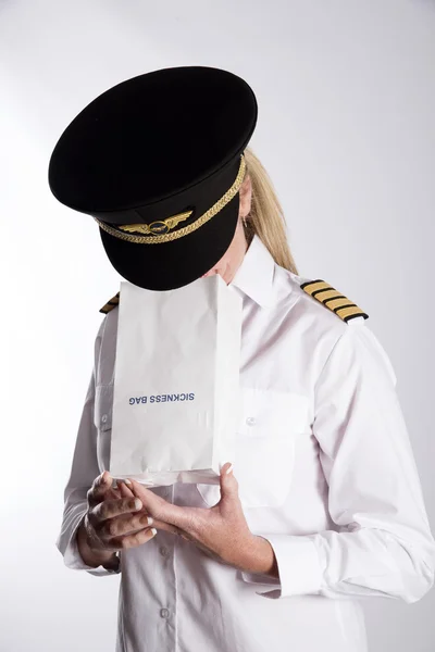 Oficial de la aerolínea usando una bolsa de enfermedad del aire — Foto de Stock