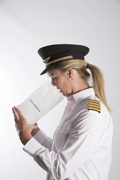Oficial de la aerolínea usando una bolsa de enfermedad del aire — Foto de Stock