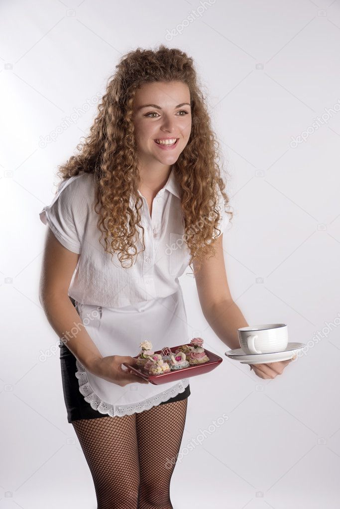 A waitress serving fairy cakes from a tray