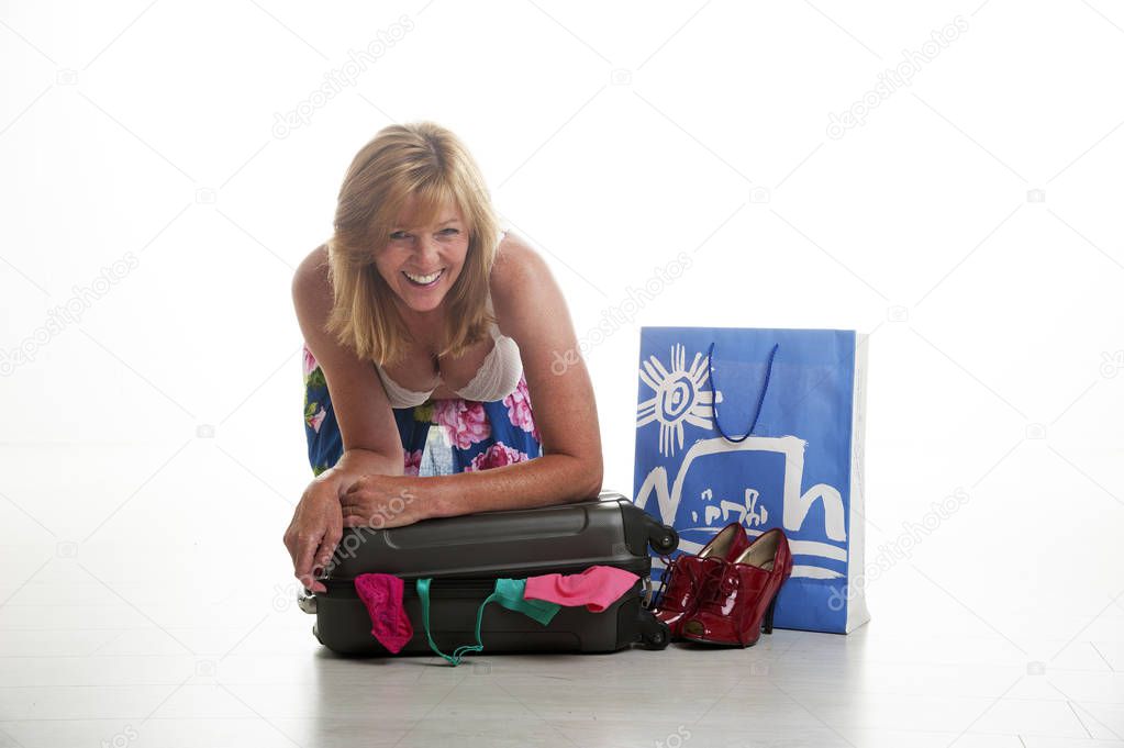 Woman trying to close a suitcase