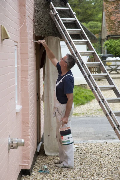 L'uomo dipinge l'esterno di una casa — Foto Stock