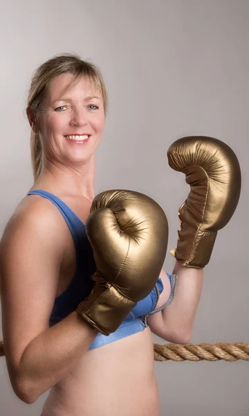 Female boxer wearing golden gloves — Stock Photo, Image