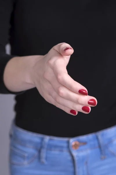 Dándole la mano a una mujer con uñas rojas — Foto de Stock