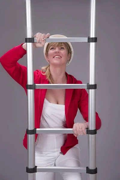 Woman climbing a telescopic ladder — Stock Photo, Image