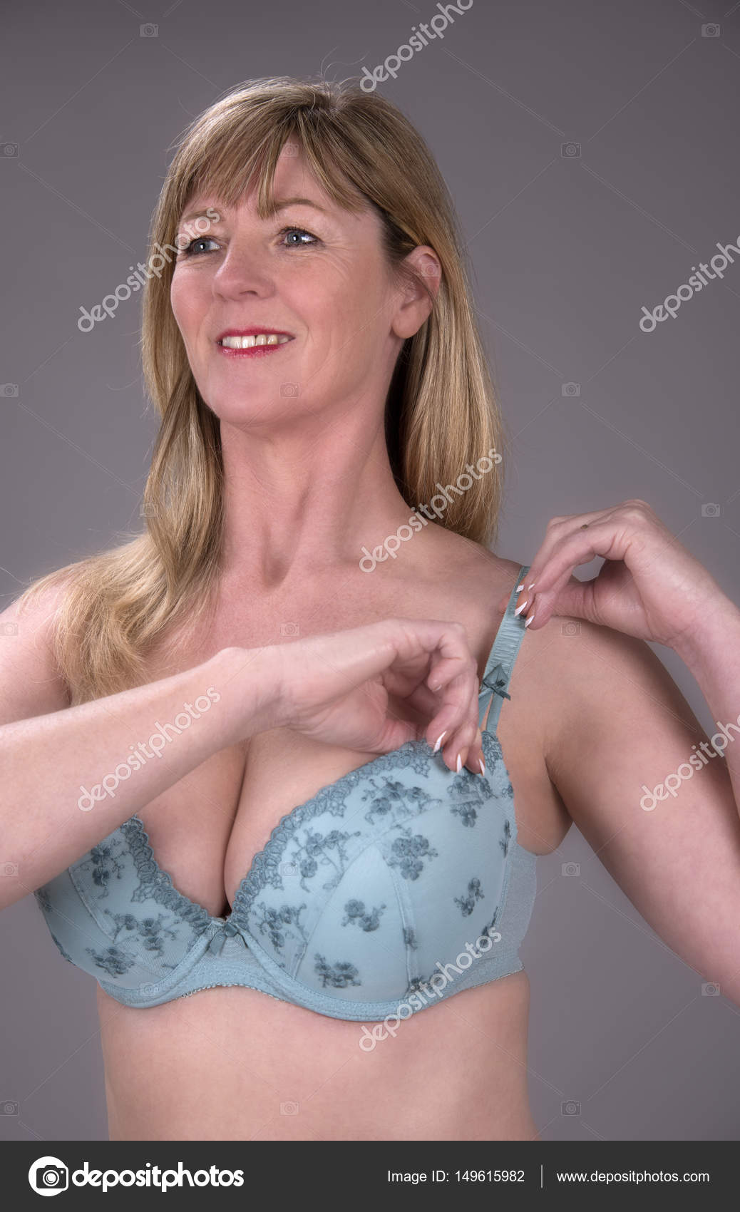 Woman dressing adjusting a bra strap Stock Photo by ©petertt 149615982