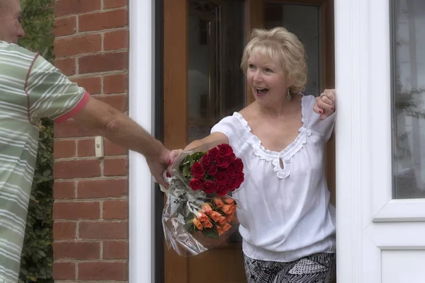 Elderly lady receving a bunch of roses — Stock Photo, Image