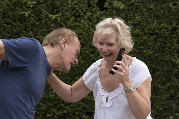 Ηλικιωμένο ζευγάρι κοινή χρήση μιας τηλεφωνικής συνομιλίας — Φωτογραφία Αρχείου