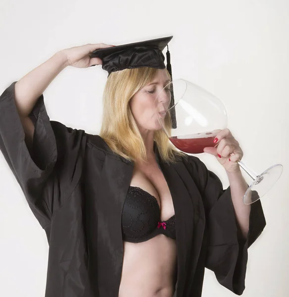 Reife Studentin mit Hut und Kleid und einem Glas Wein in der Hand — Stockfoto