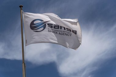 Hermanus, batı pelerini, Güney Afrika. Aralık 2019. Hermanus 'taki Güney Afrika Ulusal Uzay Ajansı binasının önünde dalgalanan Sansa bayrağı.. 