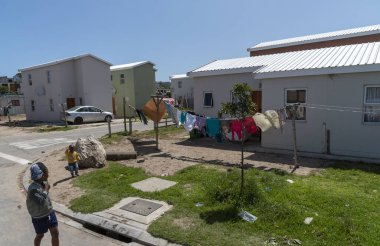 Zwelihle, Hermanus, Batı Burnu, Güney Afrika. Aralık 2019. Hermanus, Batı Burnu, Güney Afrika 'daki Zwelihle kasabasında yıkanan yol kenarındaki evler.