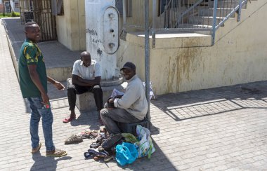 Zwelihle, Hermanus, Batı Burnu, Güney Afrika. Aralık 2019. Hermanus, Batı Burnu, Güney Afrika 'daki Zwelihle kasabasının yol kenarında ayakkabıları tamir eden ve temizleyen adam..