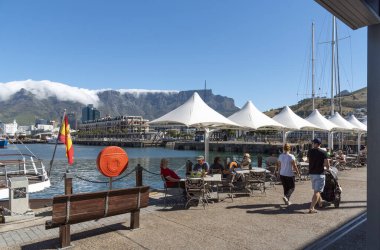 Cape Town, Güney Afrika. 2019. Turistlerin yediği, içtiği ve bulutların Masa Dağı 'nın zirvesine tırmandığı sahilin manzarası..