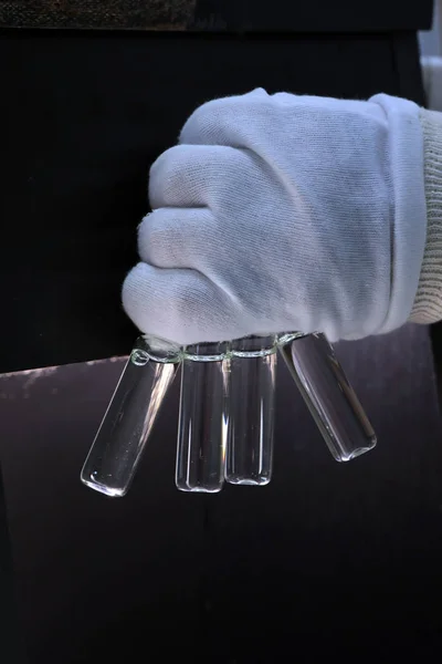 Pessoas mão segurando um tubo de ensaio conjuntos de frascos para análise no cromatógrafo líquido a gás. Assistente de laboratório a inserir frasco de vidro de laboratório num frasco de cromatógrafo — Fotografia de Stock