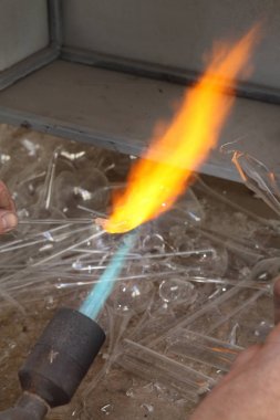 Noel oyuncak fabrikası. Alt cam darbeler. Brülör cam erir. Dekorasyon bir Noel ağacı oyuncak. El yapımı. Kürk-Ağaç oyuncak imalatı. Birçok güzel cam boncuk. Fırın yanma ürünleri.