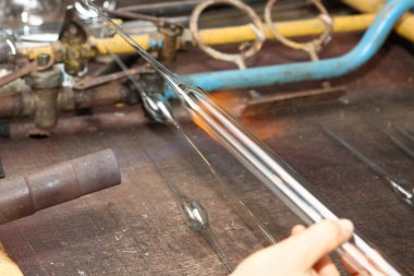 Noel oyuncak fabrikası. Alt cam darbeler. Brülör cam erir. Dekorasyon bir Noel ağacı oyuncak. El yapımı. Kürk-Ağaç oyuncak imalatı. Birçok güzel cam boncuk. Fırın yanma ürünleri.