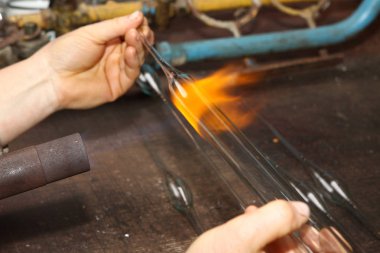 Noel oyuncak fabrikası. Alt cam darbeler. Brülör cam erir. Dekorasyon bir Noel ağacı oyuncak. El yapımı. Kürk-Ağaç oyuncak imalatı. Birçok güzel cam boncuk. Fırın yanma ürünleri.