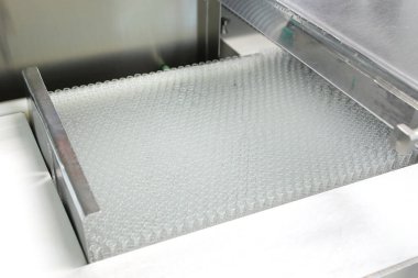 Tıpla ampullerin görsel kontrolü. Bir kadın ampul üretim bandında çalışıyor. Steril şişeler ve ampuller dağıtım hattında. İlaç ile mühürlenmiş ampuller. Steril kapsüller