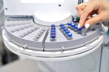 Kalite Kontrol Laboratuarı tıbbı. Kromatograf operasyonu. Bir kadın gaz kromatografı üzerinde analiz yapıyor. Covid-19 virüsüne karşı yeni bir aşı geliştirildi..