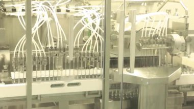 Kapsüller mühürleniyor. Test tüplerini ilaçla dolduruyorum. İlaç sanayisi. Temiz ortam.