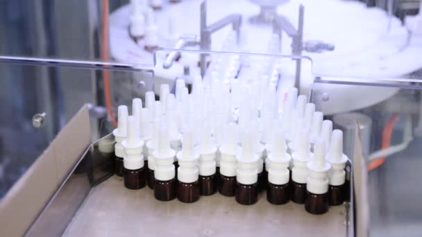 Sterile bottles and ampoules on the dispensing line. Sealed ampoules with medicine. Sterile capsules for injection Bottles on the bottling line of the pharmaceutical plant. Machine after checking. — Stock Video