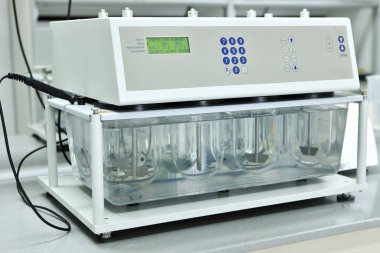 Bir kadın kimyager, hapların ve diğer dozaj formlarının çözünürlük testlerini yapar. Erveka - Bilimsel araştırma farmasötik laboratuarı. Bir adam bir fabrikada bilimsel çalışma yürütüyor. Laboratuvar araştırması.