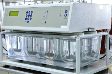 Bir kadın kimyager, hapların ve diğer dozaj formlarının çözünürlük testlerini yapar. Erveka - Bilimsel araştırma farmasötik laboratuarı. Bir adam bir fabrikada bilimsel çalışma yürütüyor. Laboratuvar araştırması.