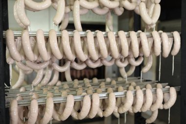 Çalışma masasında sosis hazırlıyor. Gıda işleme ve işleme endüstrisi. Çiğ et karışımı: biftek, kümes hayvanı, sosis, jambon, doğranmış et. Çiftlik. Eşsiz ev yapımı.