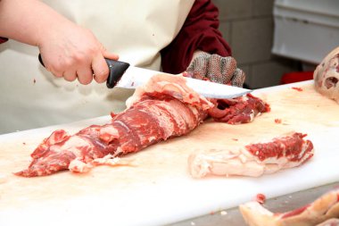 Çalışma masasında sosis hazırlıyor. Gıda işleme ve işleme endüstrisi. Çiğ et karışımı: biftek, kümes hayvanı, sosis, jambon, doğranmış et. Çiftlik. Eşsiz ev yapımı.