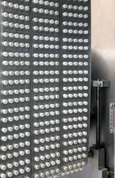 Capsule medicine pill production line, Industrial pharmaceutical concept. Tablets coming out of the machine. Pharmacy medicine pill production conveyor. Tablet pill production. Blistering conveyer