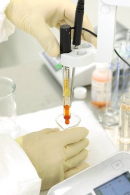 Bir kimyager çözeltinin sertliğini araştırır. Laboratuvar PH ölçümü. PH 'ı kimyasal olarak ölçmek için bir cihaz. İlaç üretimi için modern ekipman. Bir bilim adamı bir deney yapıyor..