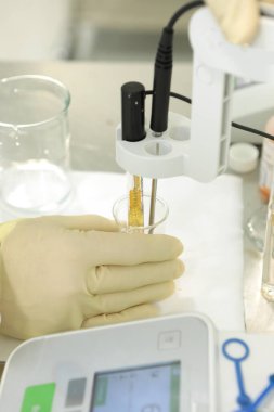 Bir kimyager çözeltinin sertliğini araştırır. Laboratuvar PH ölçümü. PH 'ı kimyasal olarak ölçmek için bir cihaz. İlaç üretimi için modern ekipman. Bir bilim adamı bir deney yapıyor..