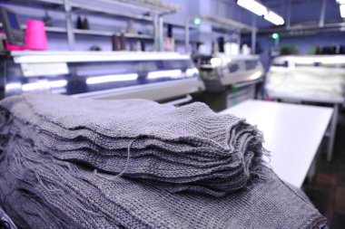 Dikiş atölyesinin arka planında pembe iplik makaraları var. Kıyafet endüstrisi. Tekstil endüstrisi için makine. Giysi imalatı. Yeni terzilik fabrikası.